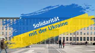 Hauptgebäude, davor Nationalfarben der Ukraine